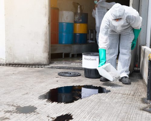 Worker in Hazmat Suit Treating Industrial Chemical Spill